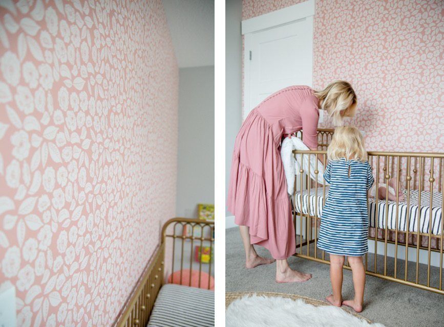 Nursery by The Simple Sweet Life with pink wallpaper called Baby Bloom from Milton & King with a gold painted crib and mother and daughter watching the baby