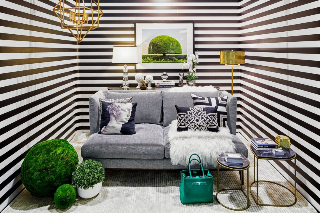 Sitting room with grey loveseat and horizontal black and white striped wallpaper