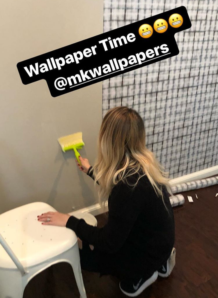 woman applying paste to the wall to hang Earth Grey Brick Wallpaper by Milton & King