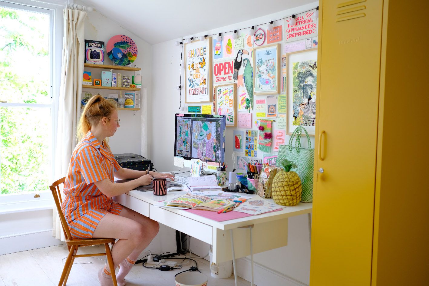 Jacqueline Colley illustrating colorful wallpaper designs in her home studio