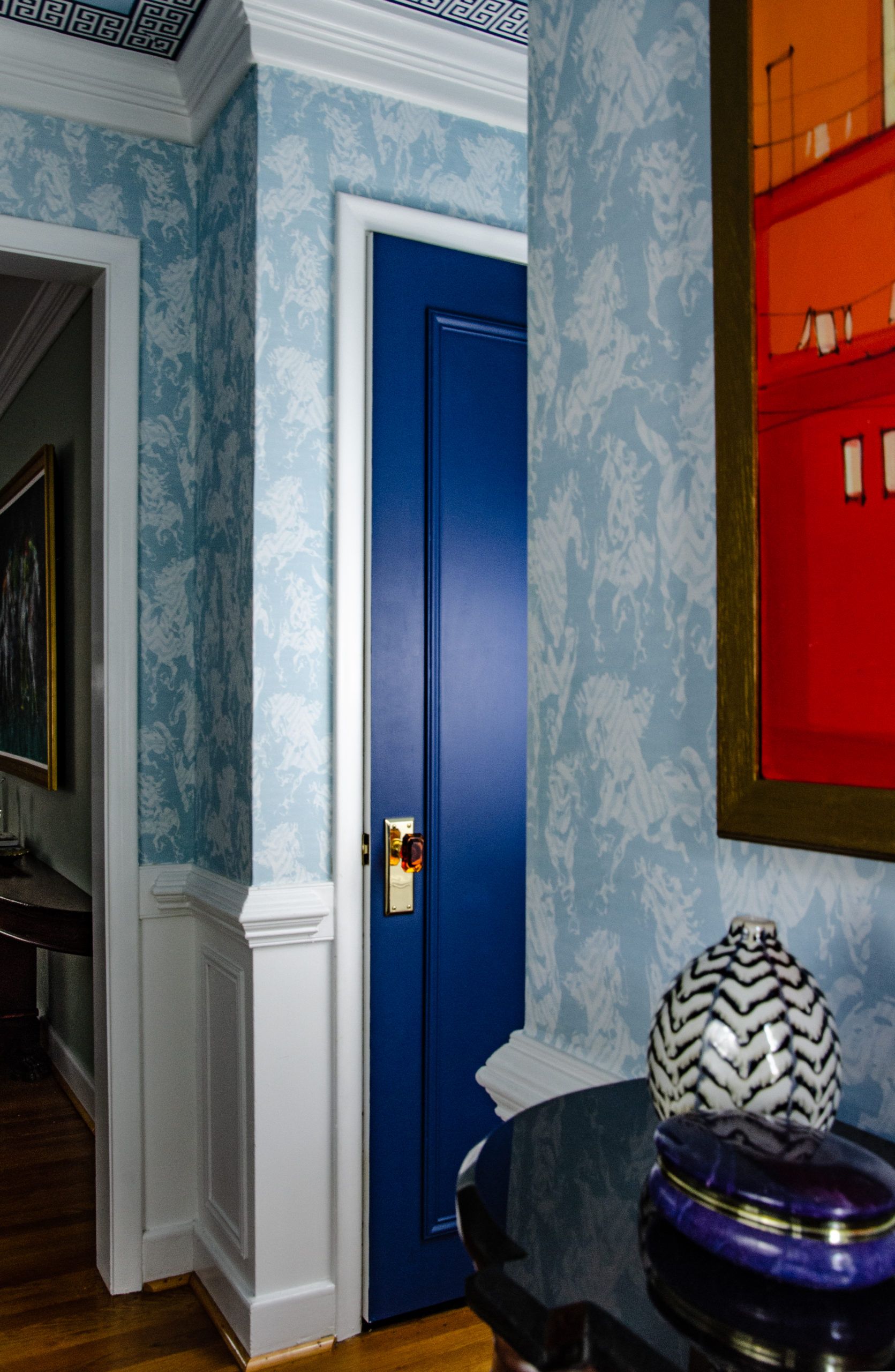 Hallway with Stampede Wallpaper by Milton & King. The wallpaper is light blue with horses. The doors are also painted light blue to match the wallpaper.