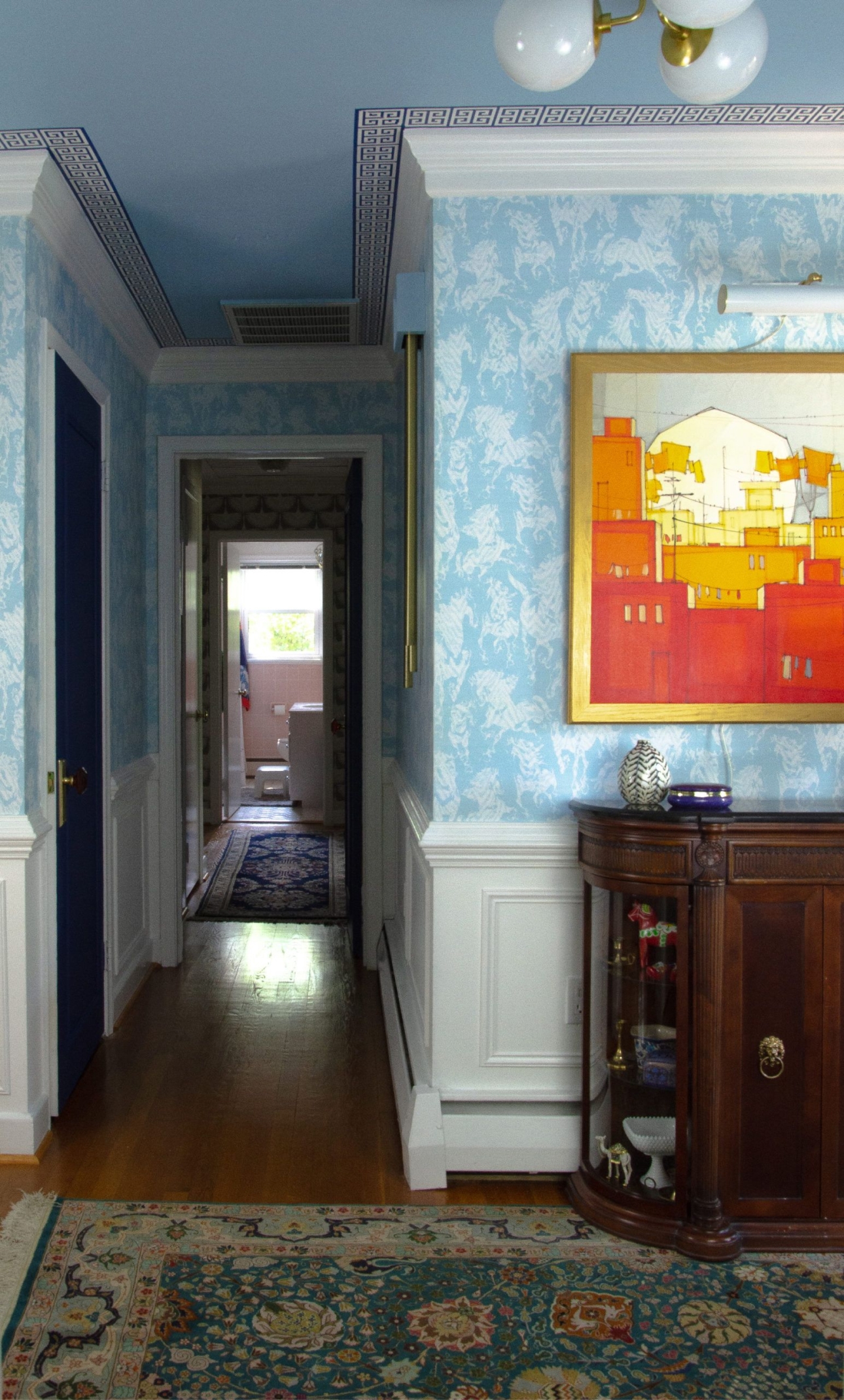 Hallway with Stampede Wallpaper by Milton & King. The wallpaper is light blue with horses. The doors are also painted light blue to match the wallpaper.