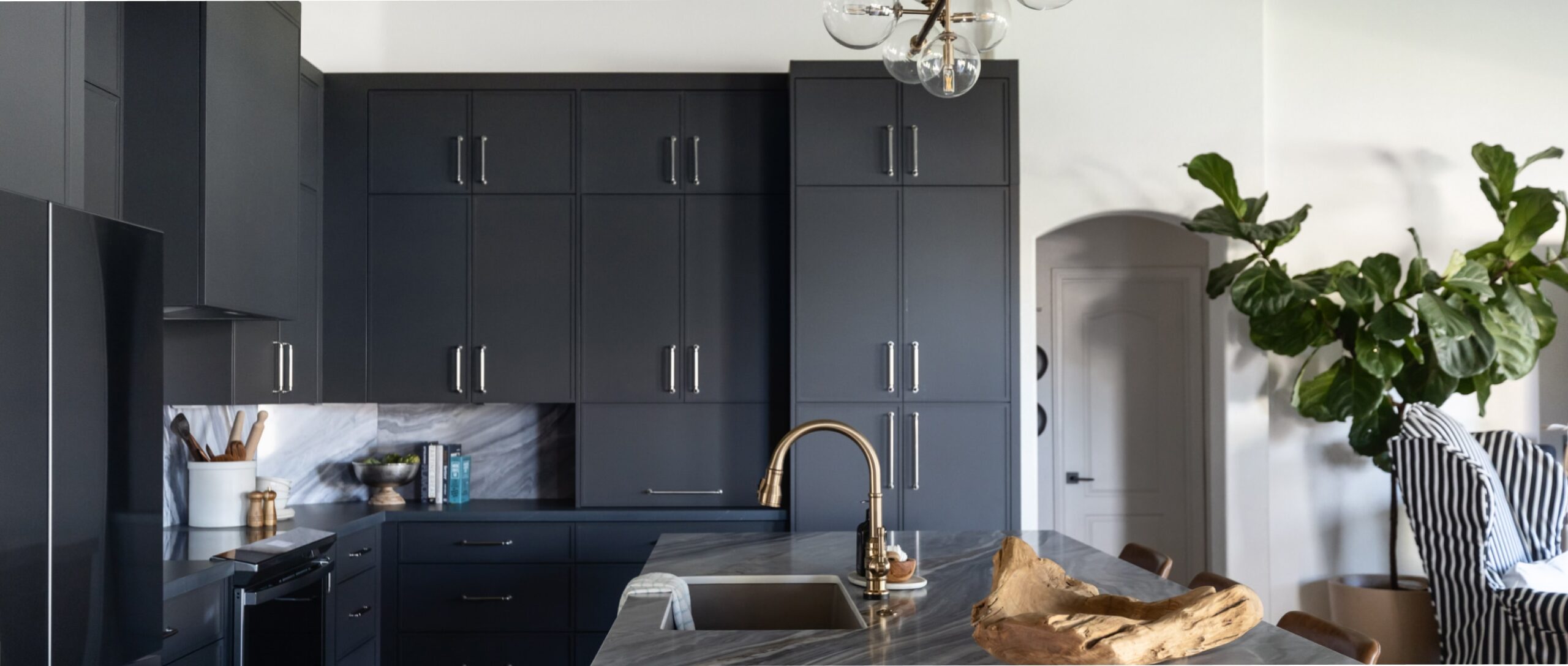 a modern kitchen with dark charcoal cabinets