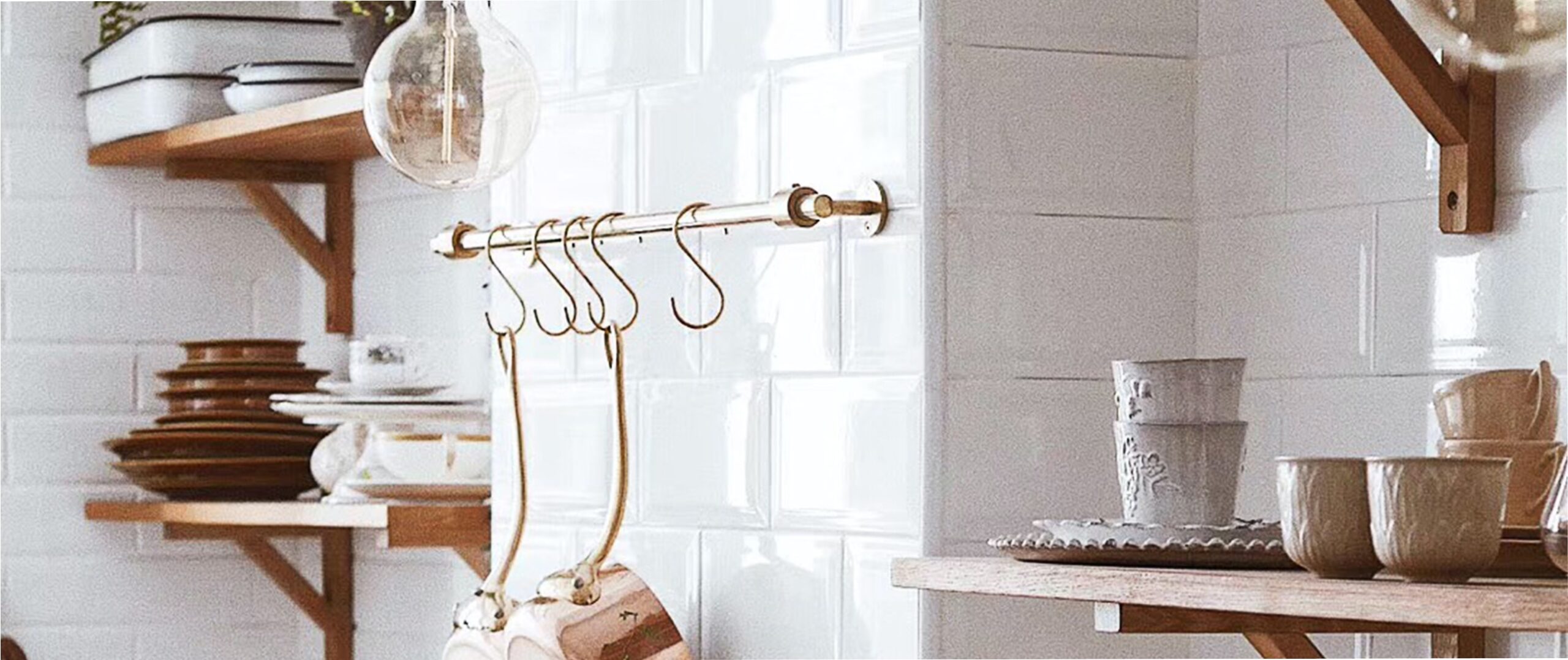 a white tiled kitchen with open wood shelves