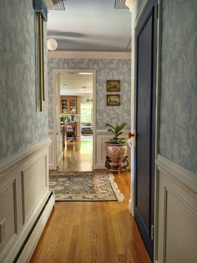 Hallway with Stampede Wallpaper by Milton & King. The wallpaper is light blue with horses. The doors are also painted light blue to match the wallpaper.