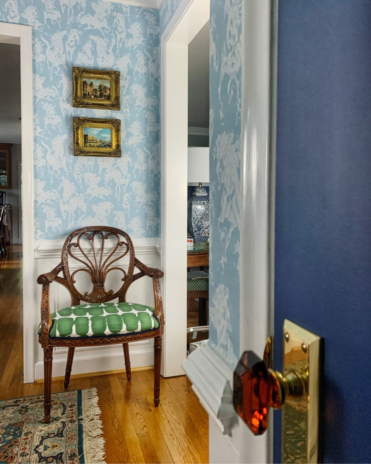 Hallway with Stampede Wallpaper by Milton & King. The wallpaper is light blue with horses. The doors are also painted light blue to match the wallpaper.