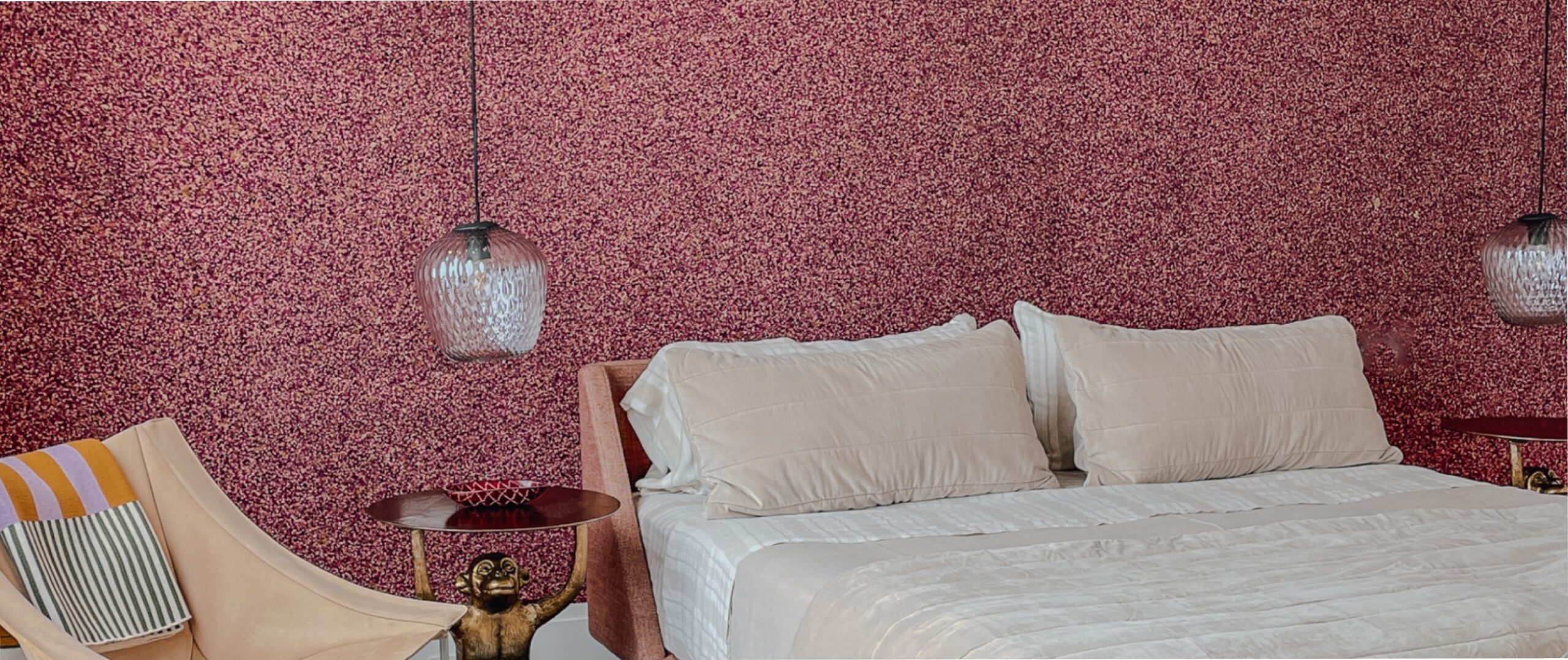 A pink wallpapered bedroom with pink confetti wallpaper