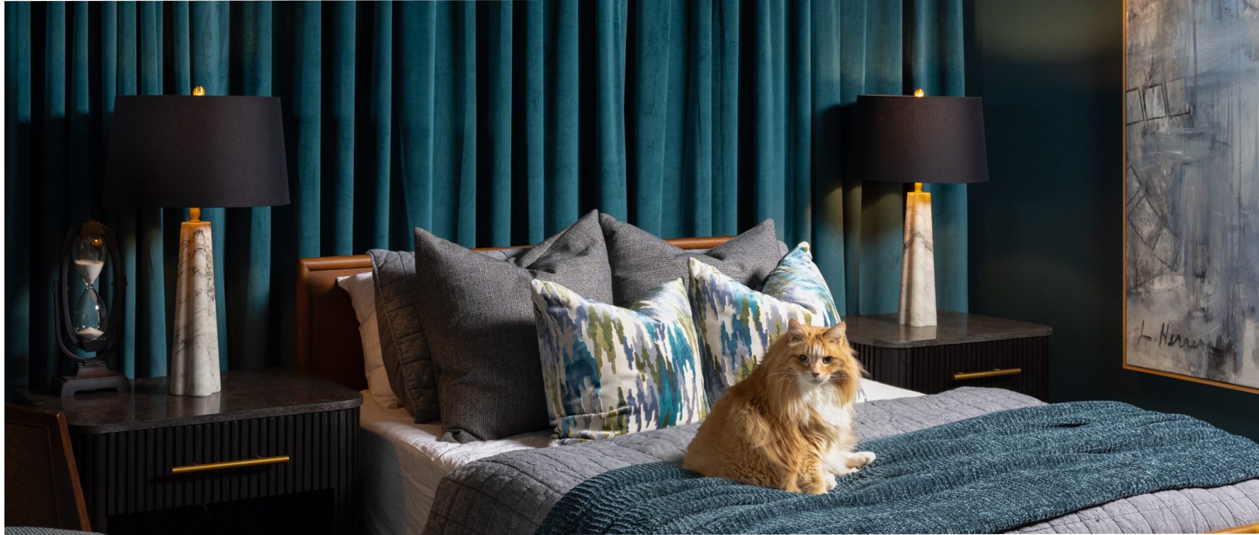 Moody teal bedroom with an orange cat on the bed