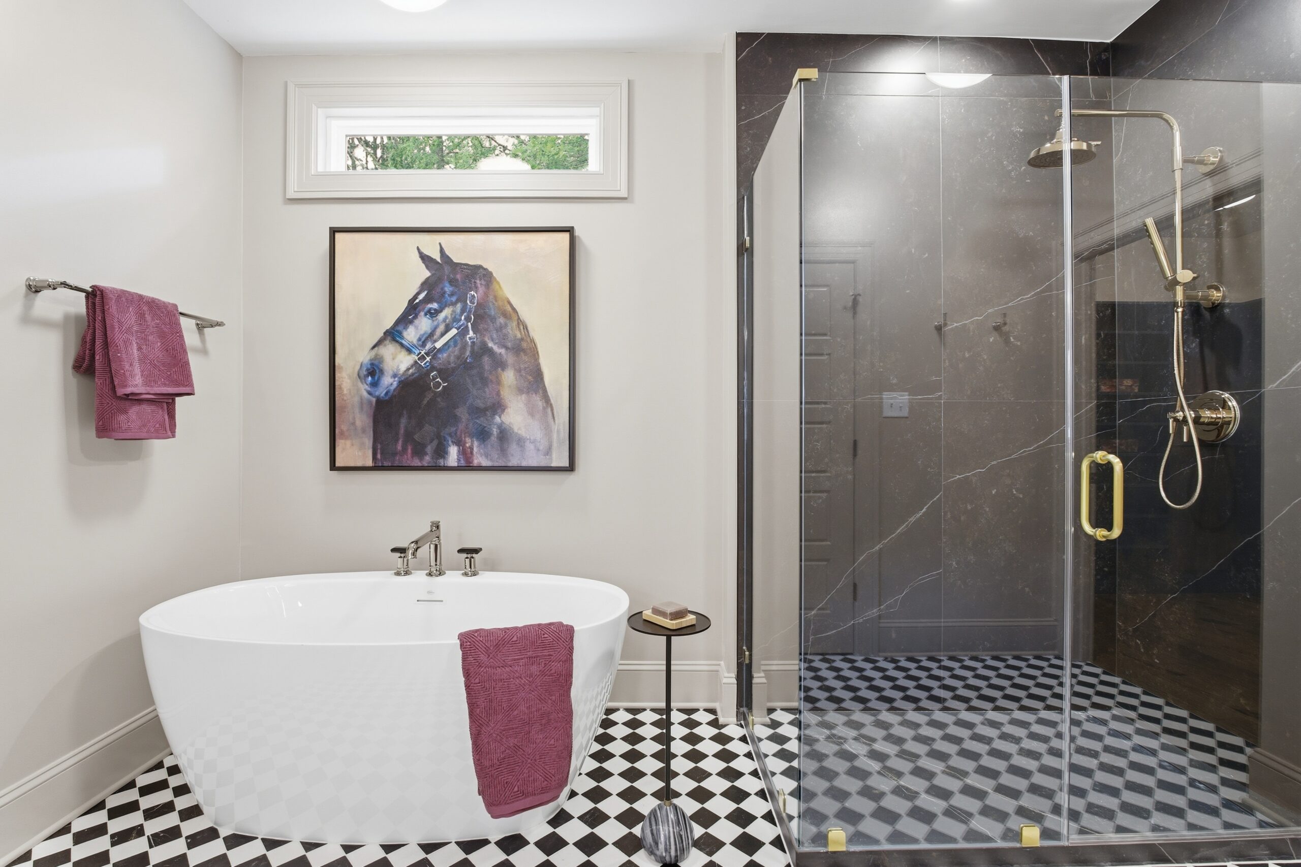 Bathroom standing shower with a bathrub to the left. Above the tub is a square picture of a horse