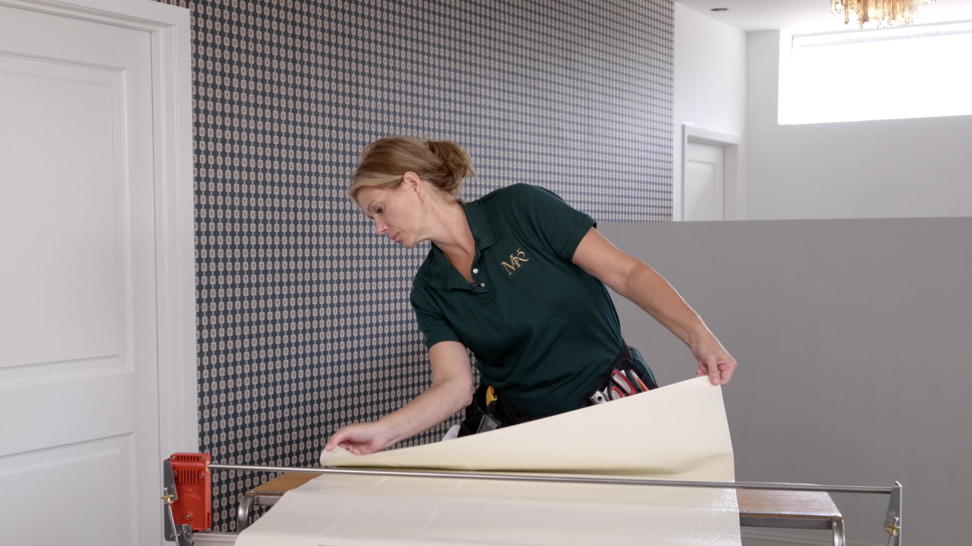 Woman applying paste to grasscloth wallpaper